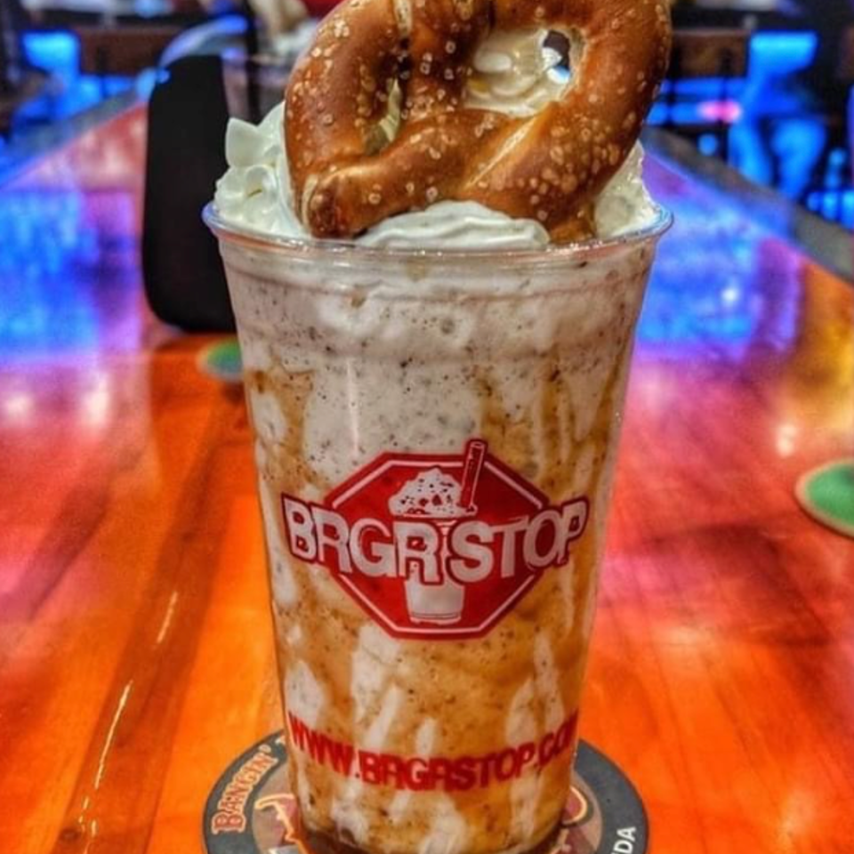 Cookies-and-cream milkshake topped with whipped cream and a large salted pretzel at Brgrstop in Pompano Beach, Florida.